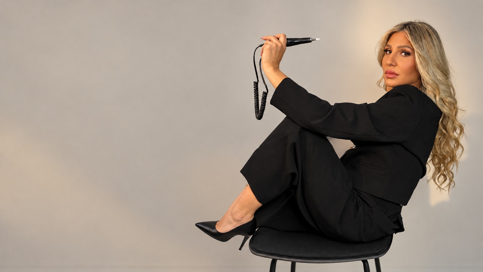Silvy seated with her nail artistry tool